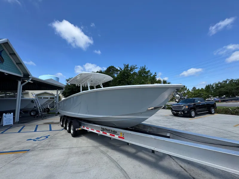 Slide: The Image of 2018 Jupiter 34 HFS boat on trailer in parking lot under clear blue sky. - 7