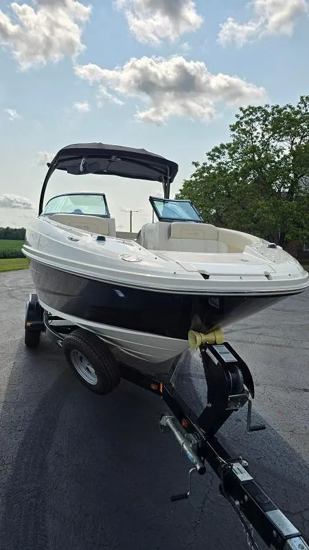 Slide: The Image of 2013 Sea Ray 240 Sundeck boat on trailer under a partly cloudy sky. - 15