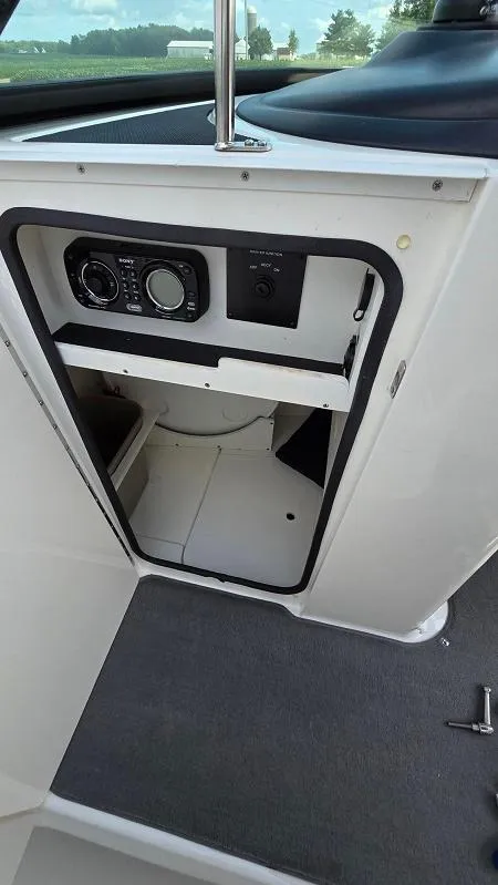 Slide: The Image of 2013 Sea Ray 240 Sundeck interior storage compartment with control panel. - 17