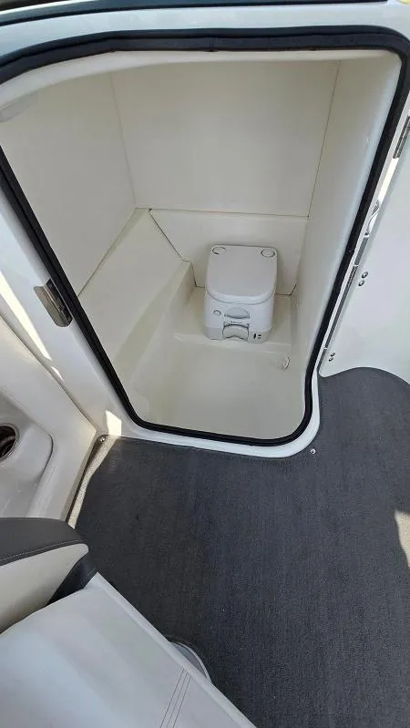 Slide: The Image of 2013 Sea Ray 240 Sundeck interior with compact marine toilet. - 18