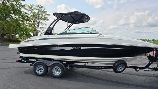 Slide: The Image of 2013 Sea Ray 240 Sundeck boat on trailer, parked outdoors. - 2