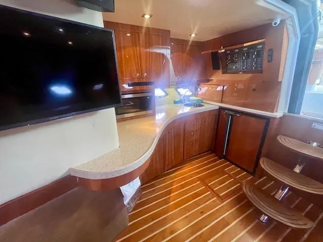 Slide: The Image of Interior of 2011 Regal 46 Sport Coupe yacht with wood flooring and modern amenities. - 10