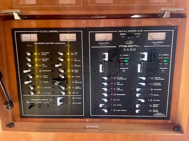 Slide: The Image of Control panel of a 2011 Regal 46 Sport Coupe boat, featuring electrical switches and meters. - 11