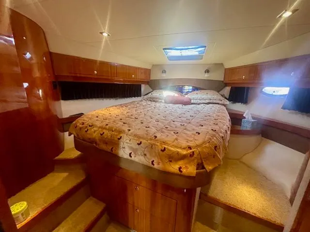 Slide: The Image of Luxurious cabin interior of 2011 Regal 46 Sport Coupe with cozy bed and wooden accents. - 13