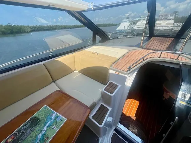 Slide: The Image of Interior of 2011 Regal 46 Sport Coupe yacht with seating and table, overlooking water. - 25