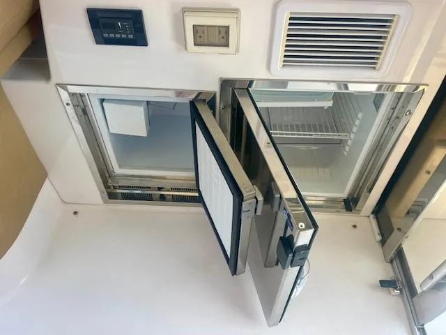 Slide: The Image of 2011 Regal 46 Sport Coupe interior with open stainless steel refrigerator and control panel. - 28