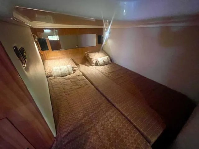 Slide: The Image of Twin beds in 2011 Regal 46 Sport Coupe cabin, featuring cozy bedding and wooden accents. - 4