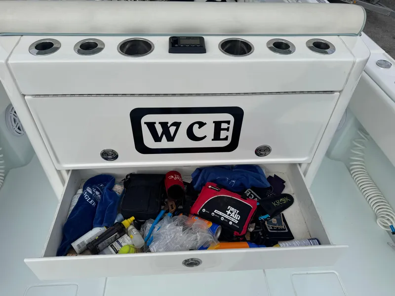 Slide: The Image of 2019 Contender 35 ST boat storage compartment with various items and WCE logo. - 20