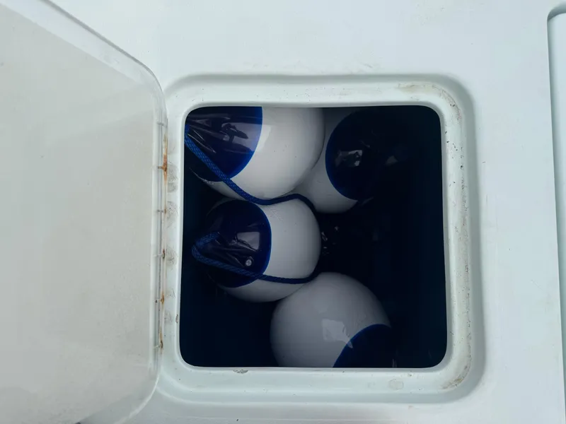 Slide: The Image of Open storage compartment on 2019 Contender 35 ST boat with white and blue buoys inside. - 36