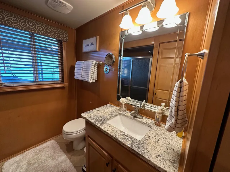 Slide: The Image of Modern bathroom with granite countertop, wooden cabinets, and ambient lighting in a 2008 Starlite 18x85. - 11