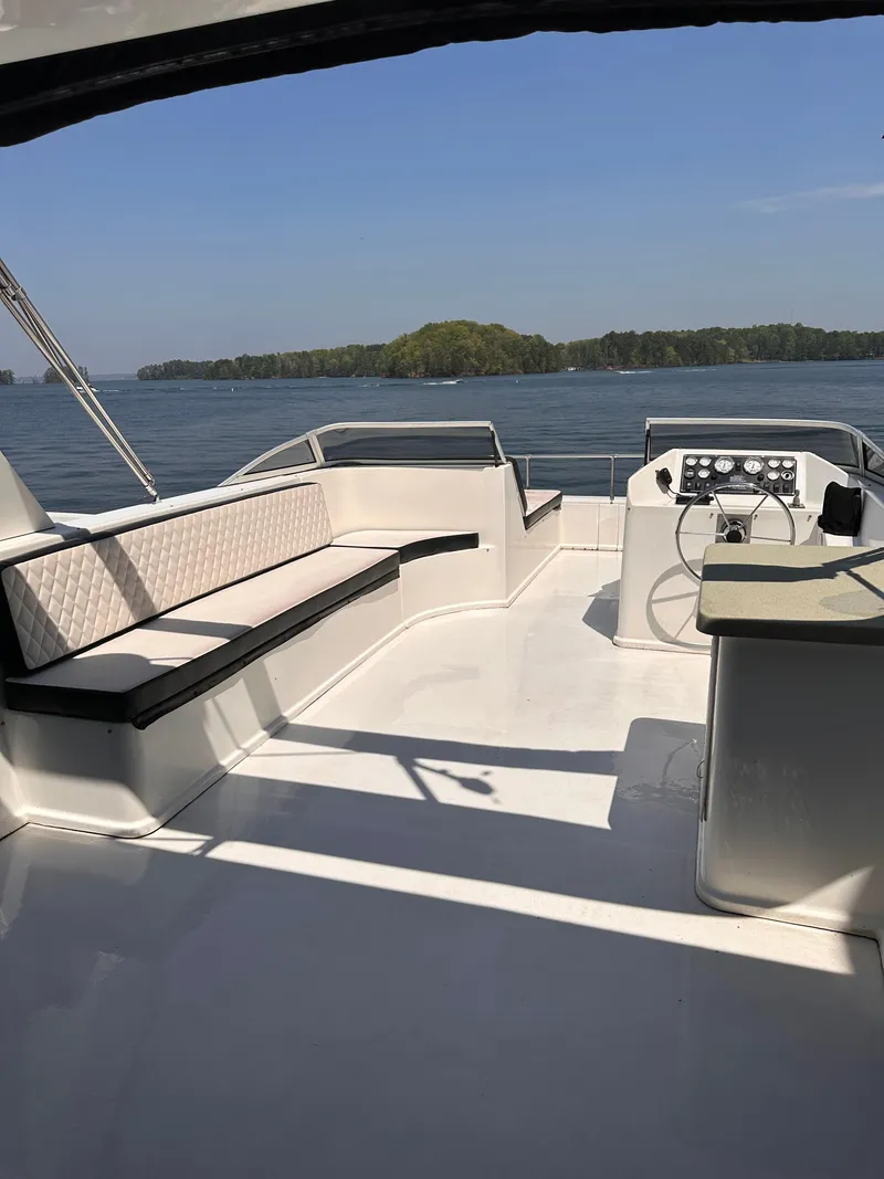 Slide: The Image of 2008 Starlite 18x85 boat interior with seating and steering, on a calm lake. - 18