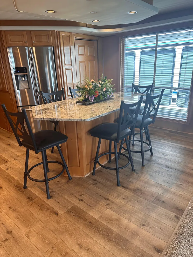 Slide: The Image of Modern kitchen with granite island, black chairs, and wood flooring in a 2008 Starlite 18x85. - 6