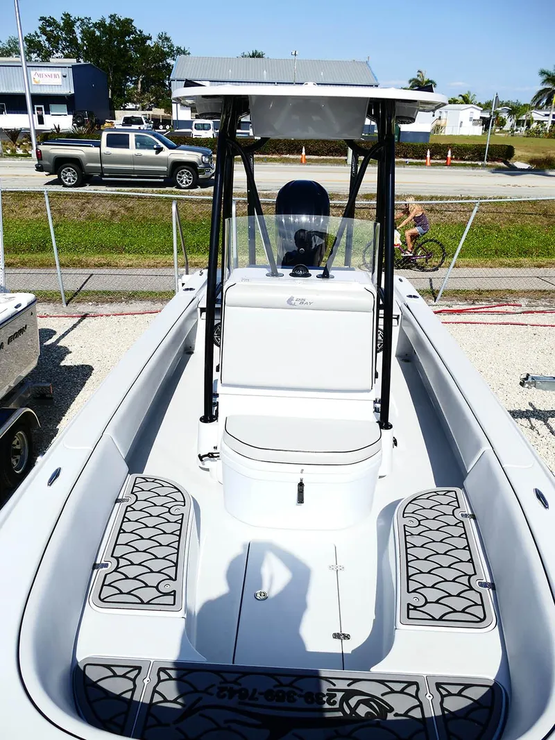 Slide: The Image of 2022 Contender 25 Bay boat with T-top and spacious deck, parked outdoors. - 26