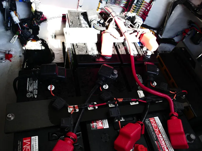 Slide: The Image of Battery setup in a 2022 Contender 25 Bay boat, featuring red and black cables. - 32