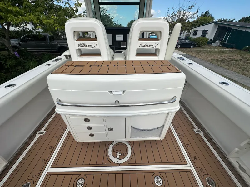 Slide: The Image of 2013 Boston Whaler 320 Outrage boat interior with seating and storage compartments. - 11