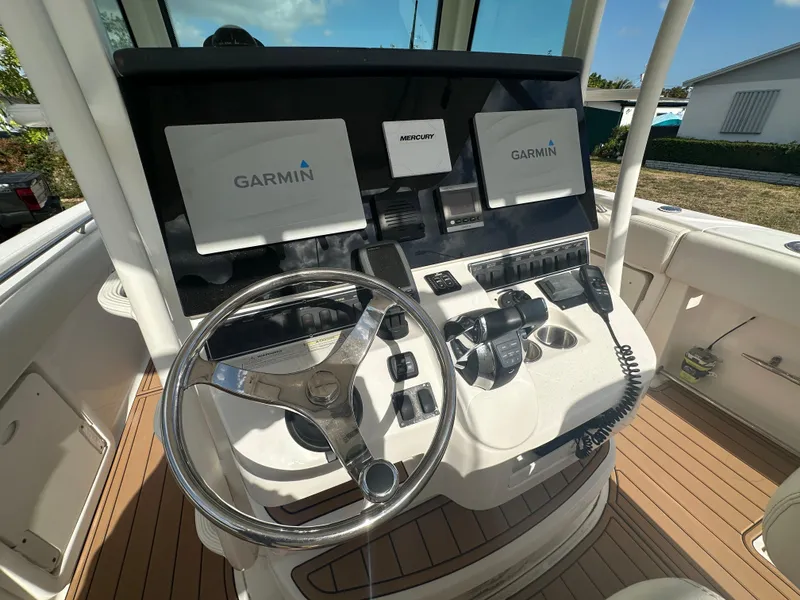 Slide: The Image of 2013 Boston Whaler 320 Outrage helm with Garmin displays and Mercury controls. - 15