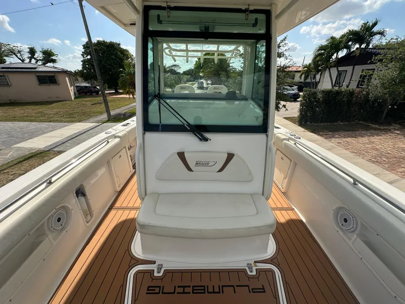 Slide: The Image of 2013 Boston Whaler 320 Outrage boat interior with seating and deck view. - 18