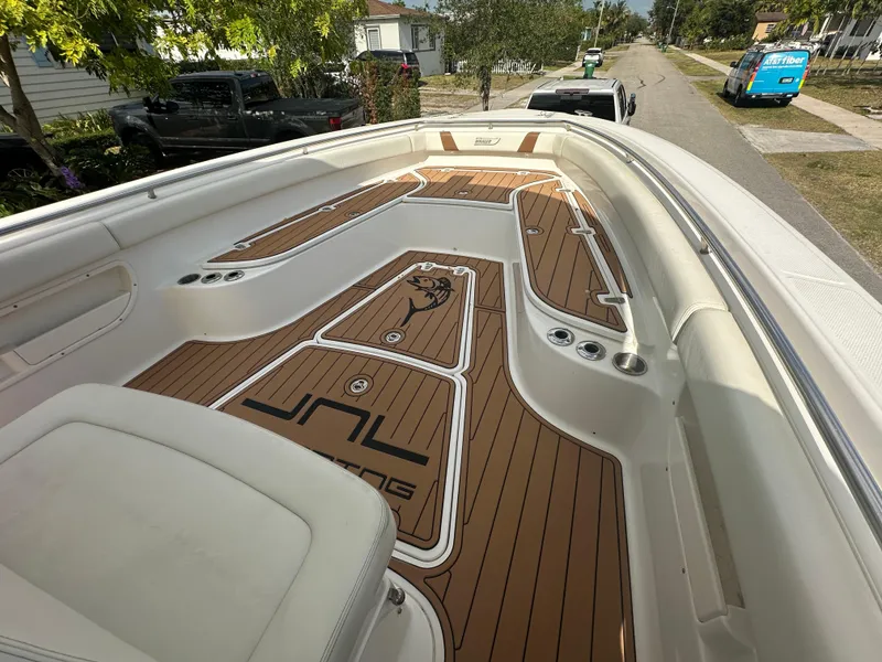 Slide: The Image of 2013 Boston Whaler 320 Outrage boat with custom deck flooring, parked on a residential street. - 21