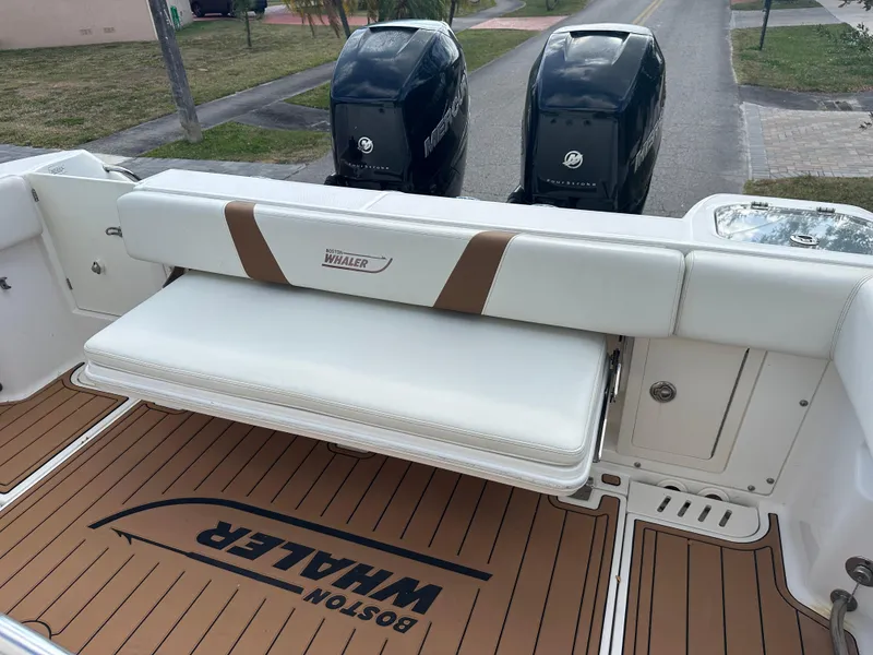Slide: The Image of 2013 Boston Whaler 320 Outrage boat with cushioned seating and twin Mercury engines. - 29