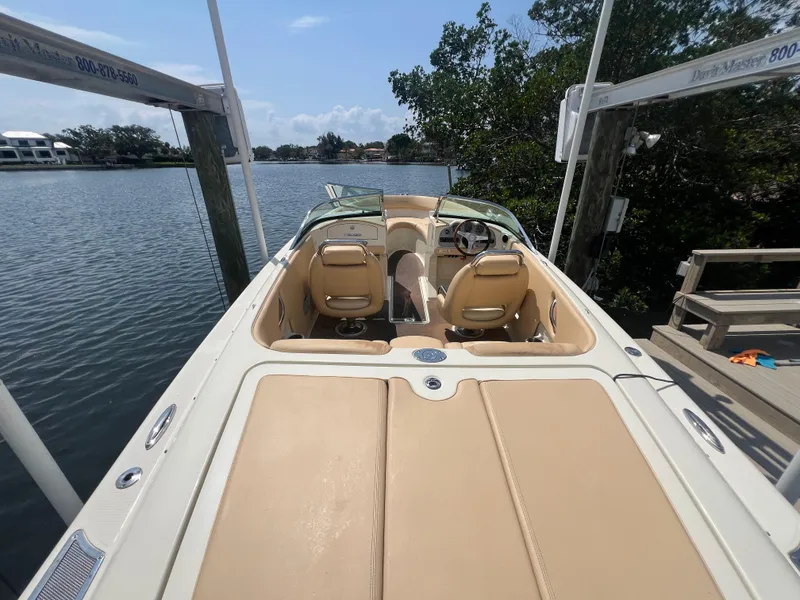 Slide: The Image of 2013 Chris-Craft Launch 22 boat docked by a serene waterfront. - 2