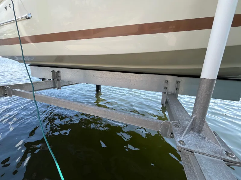 Slide: The Image of 2013 Chris-Craft Launch 22 boat on a lift above water. - 22