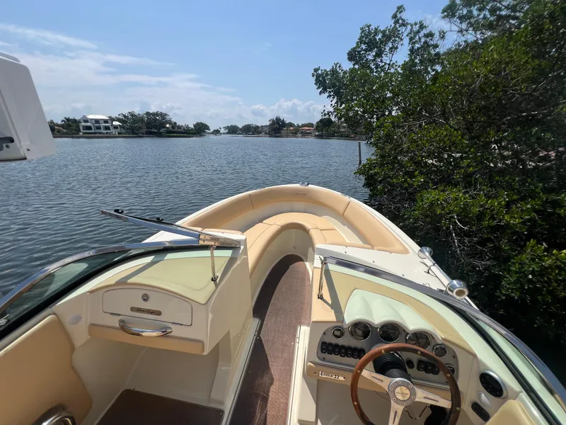 Slide: The Image of 2013 Chris-Craft Launch 22 boat on a scenic lake with lush greenery. - 5
