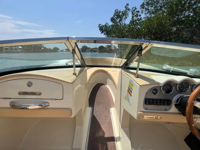 Slide: The Image of 2013 Chris-Craft Launch 22 boat interior with dashboard and steering wheel, on a sunny day. - 6