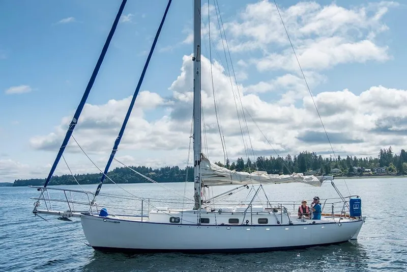 Slide: The Image of 2011 Cape George Cutter sailboat on calm water under a partly cloudy sky. - 0