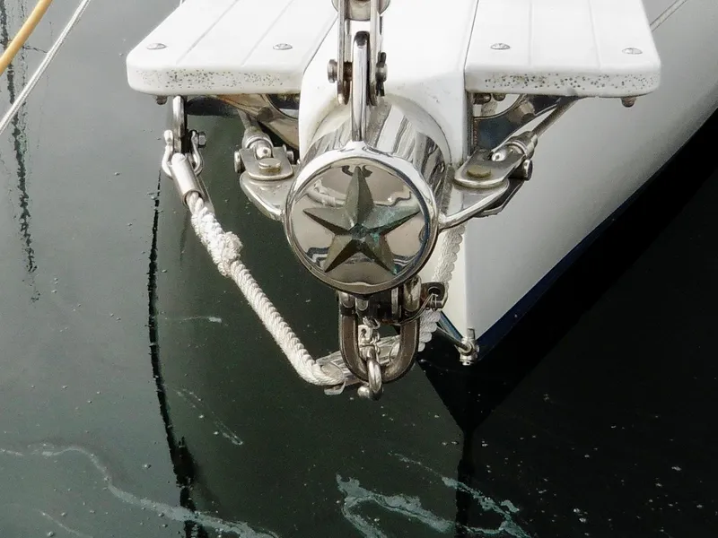 Slide: The Image of Cape George Cutter 2011 bow with anchor and star emblem on calm water. - 19