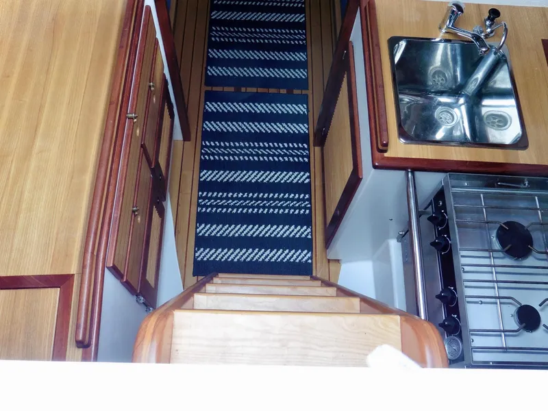Slide: The Image of Interior of 2011 Cape George Cutter with wooden cabinetry, sink, and stove. - 27