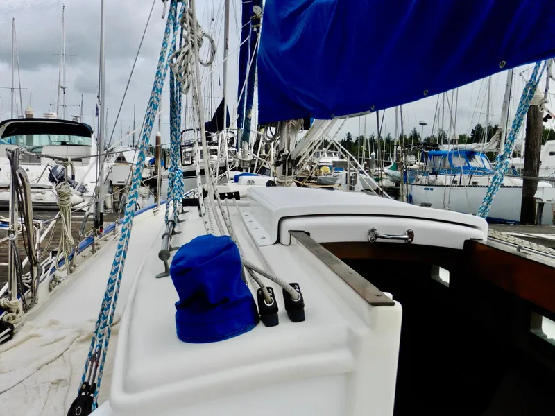 Slide: The Image of 2011 Cape George Cutter sailboat docked, featuring blue sails and rigging. - 28