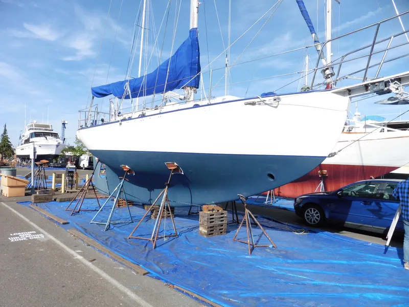 Slide: The Image of Cape George Cutter 2011 sailboat on stands, blue tarp, marina setting. - 3