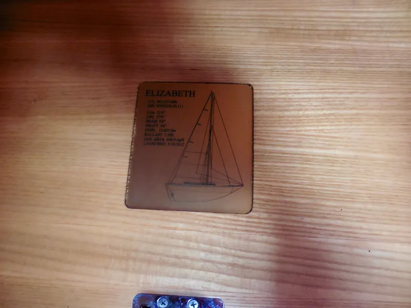 Slide: The Image of Plaque on wooden surface displaying Cape George Cutter sailboat specifications, 2011 model. - 36