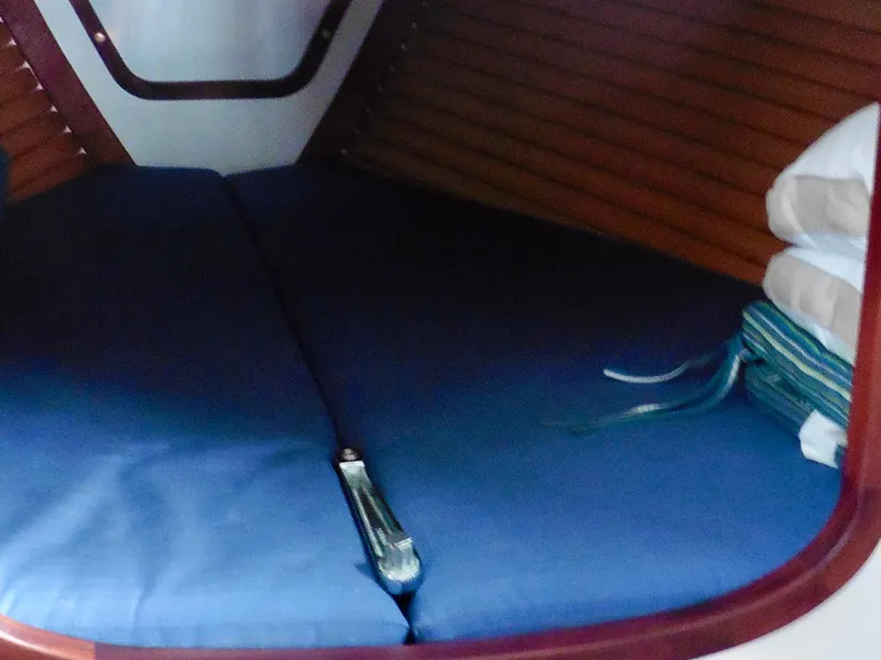Slide: The Image of Cozy cabin interior of 2011 Cape George Cutter with blue cushions and wooden paneling. - 43