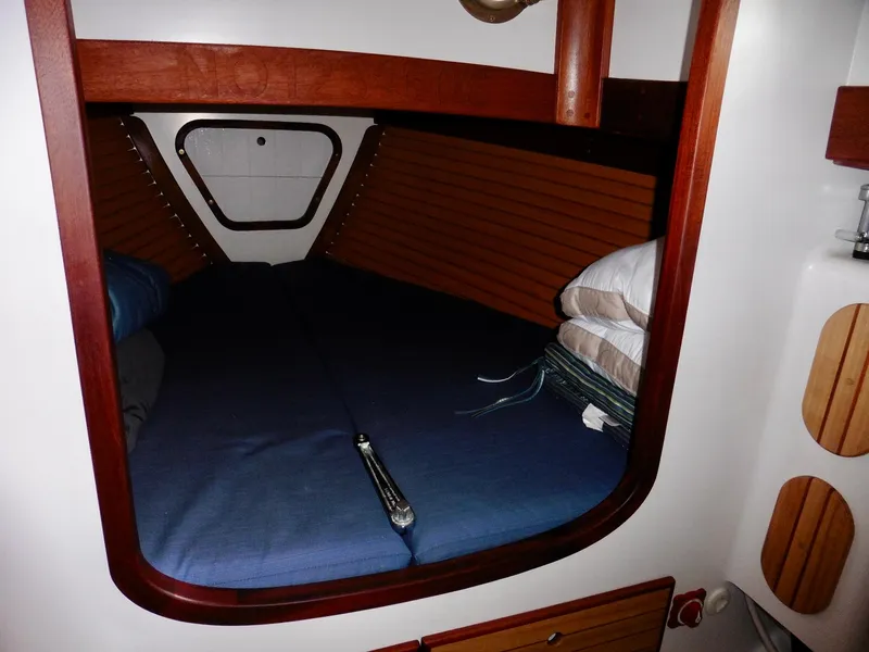 Slide: The Image of Cozy cabin interior of 2011 Cape George Cutter sailboat with blue bedding and wooden accents. - 46