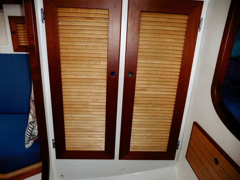 Slide: The Image of Wooden louvered cabinet doors inside a 2011 Cape George Cutter sailboat. - 49