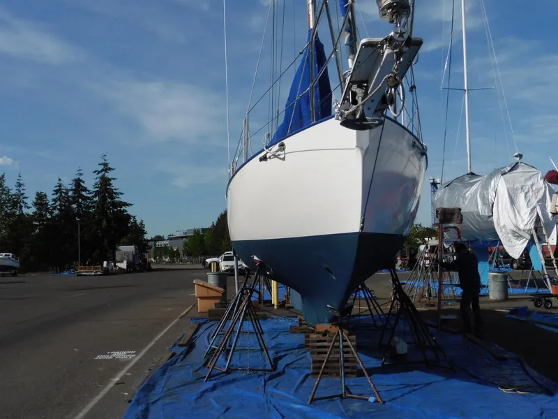 Slide: The Image of 2011 Cape George Cutter sailboat on stands, blue tarp, marina setting. - 5