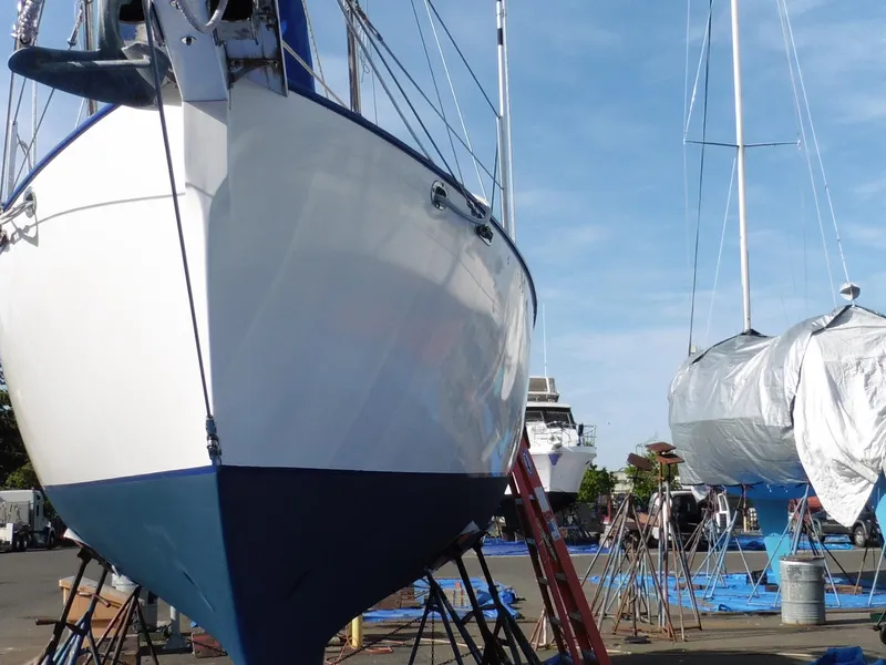 Slide: The Image of Cape George Cutter 2011 sailboats in dry dock, undergoing maintenance under clear blue skies. - 7