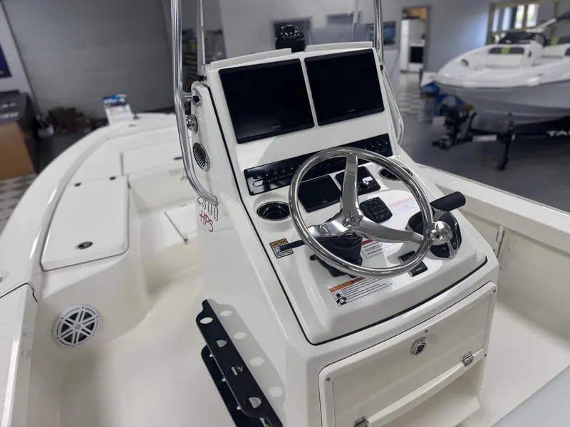 Slide: The Image of 2025 Pathfinder 2300 HPS boat console with dual screens and steering wheel. - 2