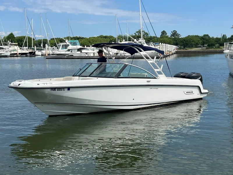Slide: The Image of 2016 Boston Whaler 270 Vantage boat on calm water, surrounded by other boats. - 0