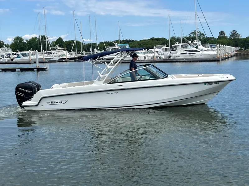 Slide: The Image of 2016 Boston Whaler 270 Vantage boat cruising in a marina with calm waters. - 1