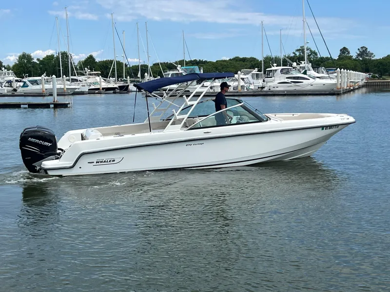 Slide: The Image of 2016 Boston Whaler 270 Vantage boat cruising in a marina with clear skies. - 13