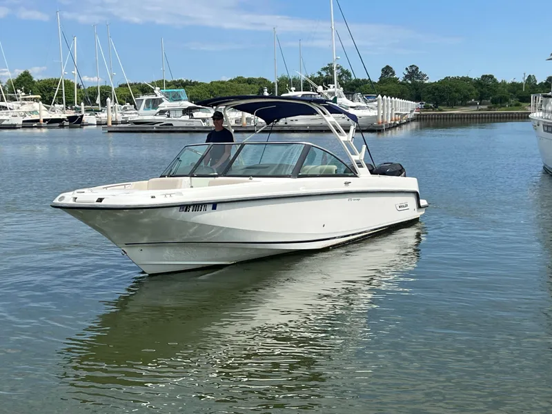 Slide: The Image of 2016 Boston Whaler 270 Vantage boat cruising in a marina with other vessels. - 14