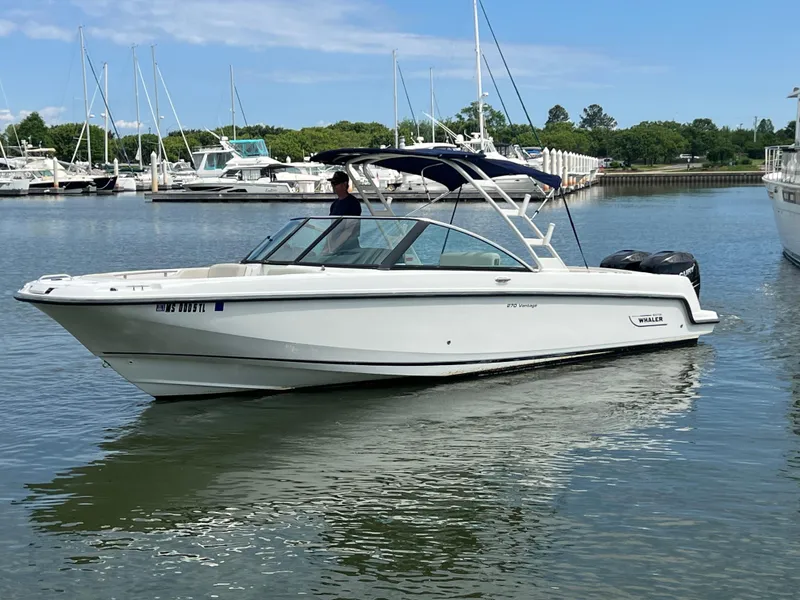 Slide: The Image of 2016 Boston Whaler 270 Vantage boat on calm water, surrounded by other boats. - 15