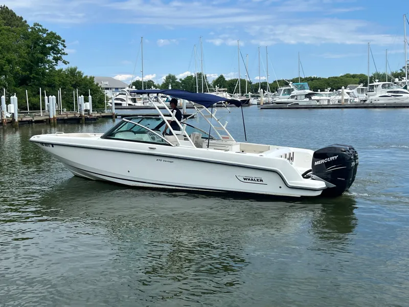 Slide: The Image of 2016 Boston Whaler 270 Vantage boat on calm water near marina. - 17
