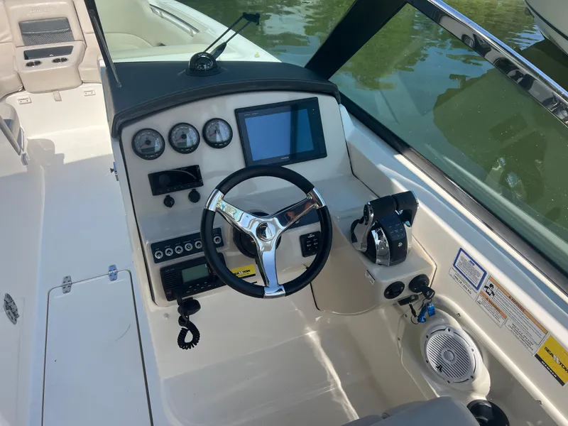 Slide: The Image of 2016 Boston Whaler 270 Vantage boat dashboard with steering wheel and control panel. - 7