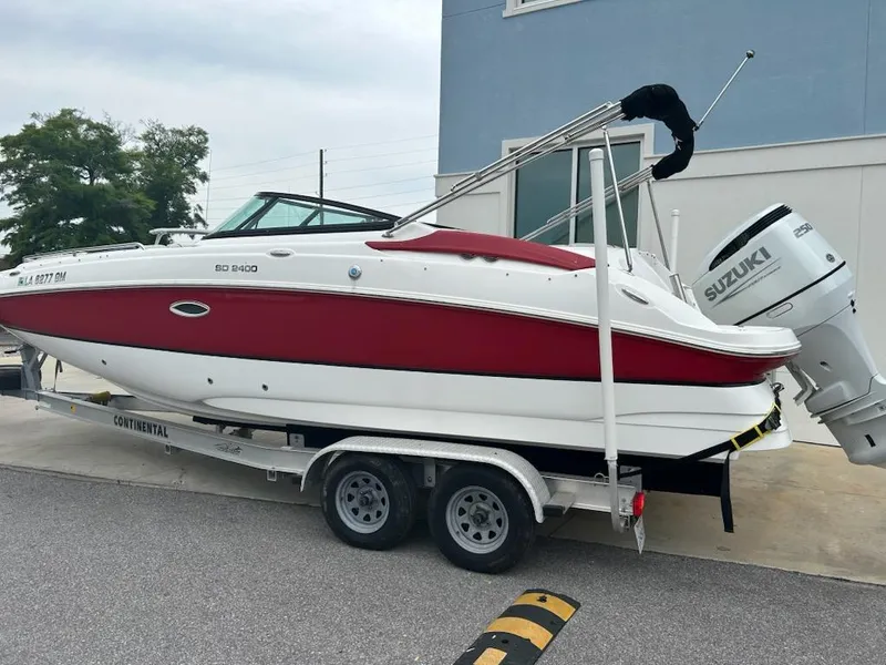 Slide: The Image of 2021 Hurricane SunDeck 2400 OB boat on trailer, featuring red and white design. - 1