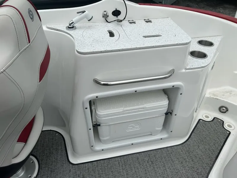 Slide: The Image of 2021 Hurricane SunDeck 2400 OB boat interior with sink, cooler, and cup holders. - 10