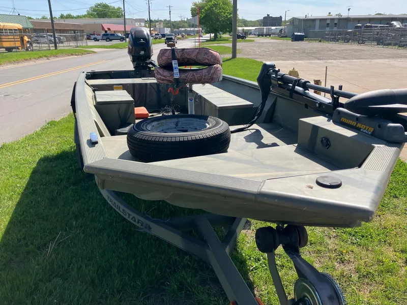 Slide: The Image of 2006 Tracker GRIZZLY 1648 AWL boat on grass, equipped with motor and spare tire. - 11
