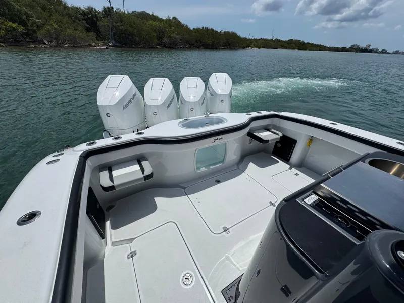 Slide: The Image of 2023 Yellowfin 42 boat with quad engines on calm water, featuring spacious deck and seating. - 18